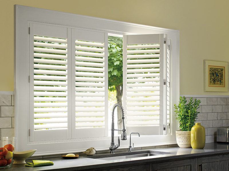 Hunter Douglas white shutters behind a kitchen sink