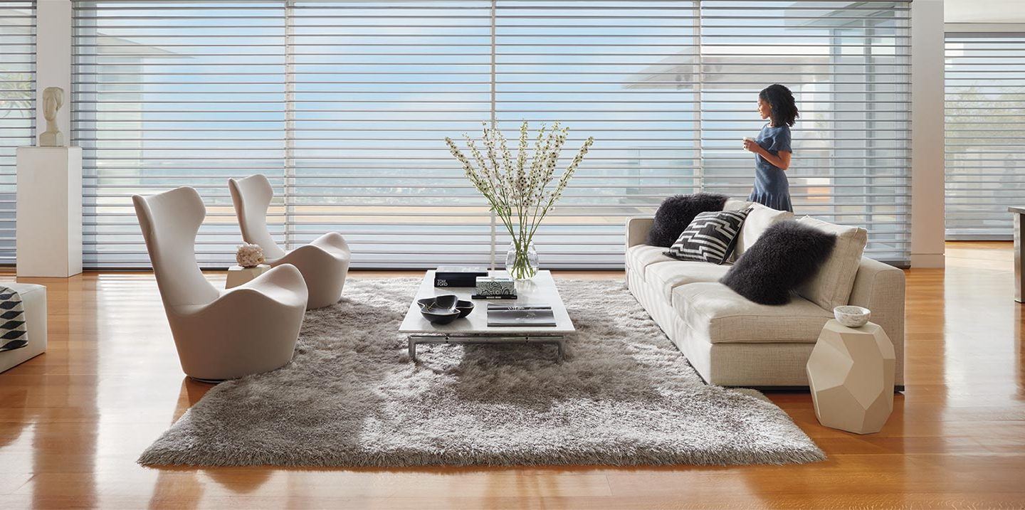 woman standing next to horizontal blinds in her living room