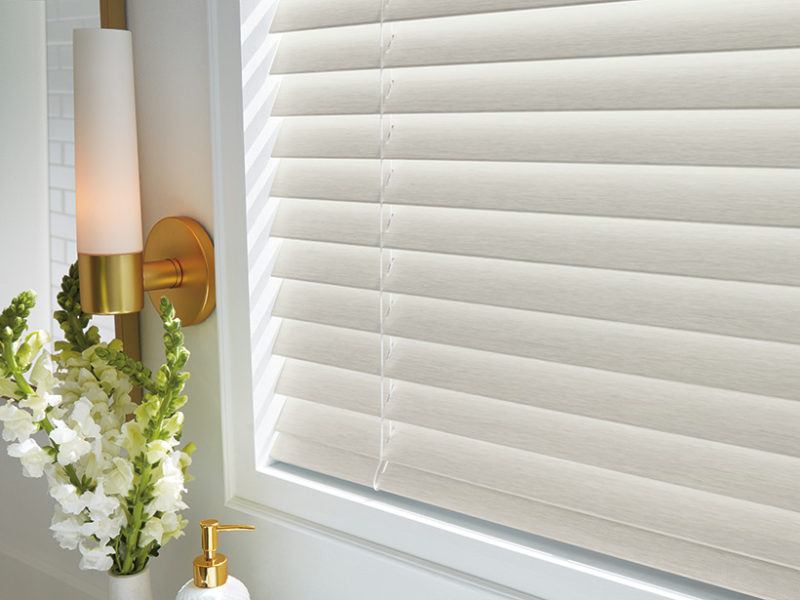 Close up photo of white cord-lock faux wood blinds