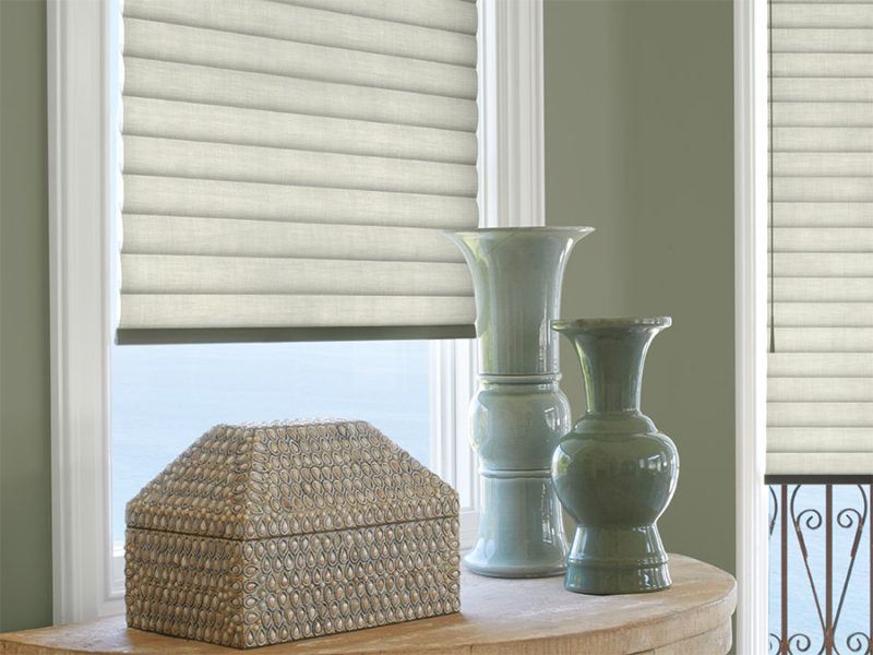 Hunter Douglas Sonnette soft touch blinds featured behind two blue vases and a decorative box