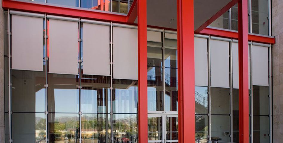 a commercial building with red pillars using exterior shade blinds