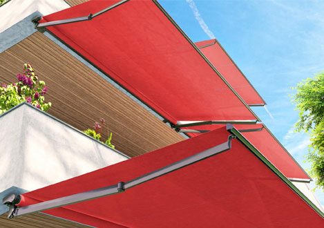 an outdoor patio covered by bright red retractable awnings