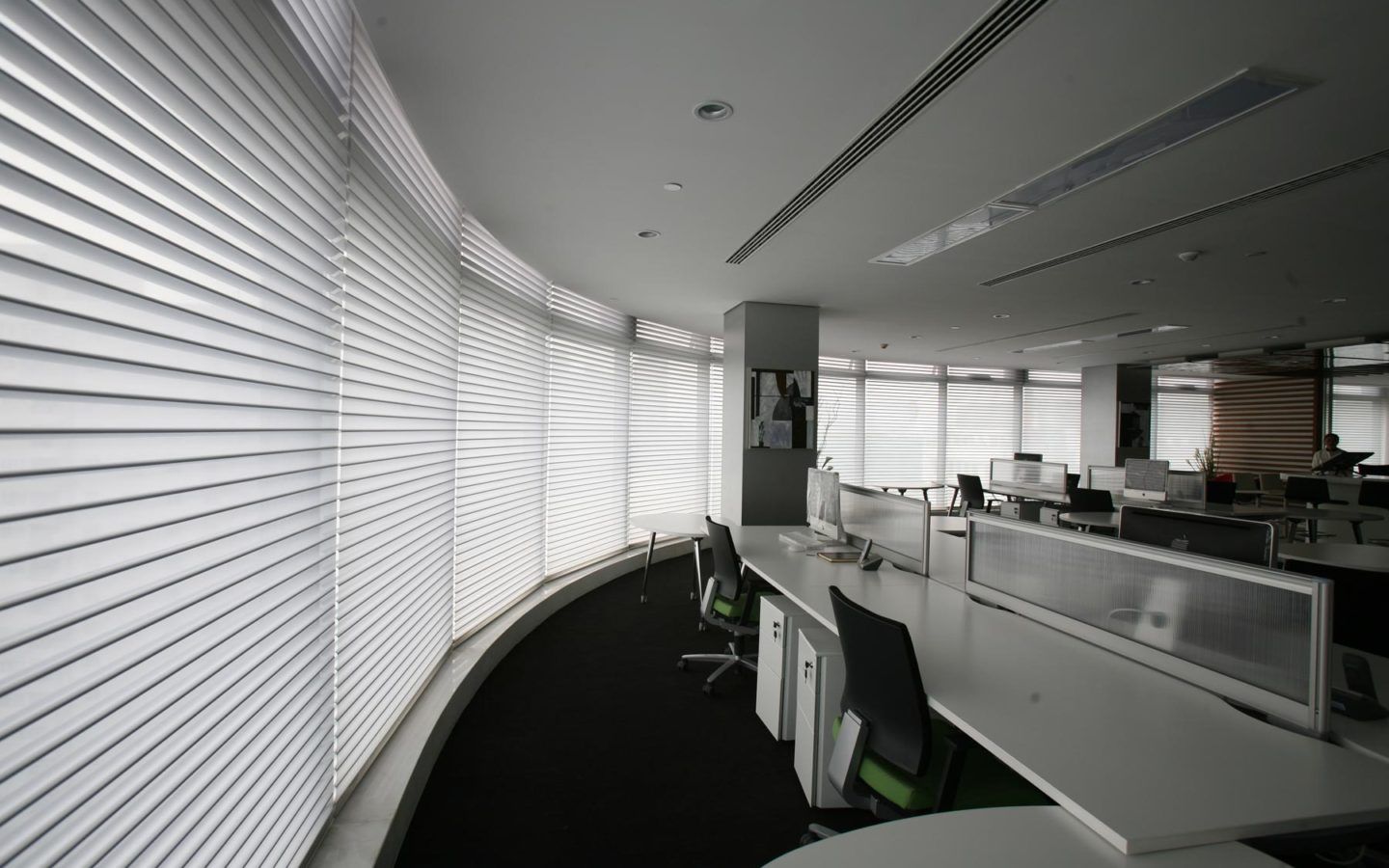 the interior of a commercial office with large windows with horizontal blinds