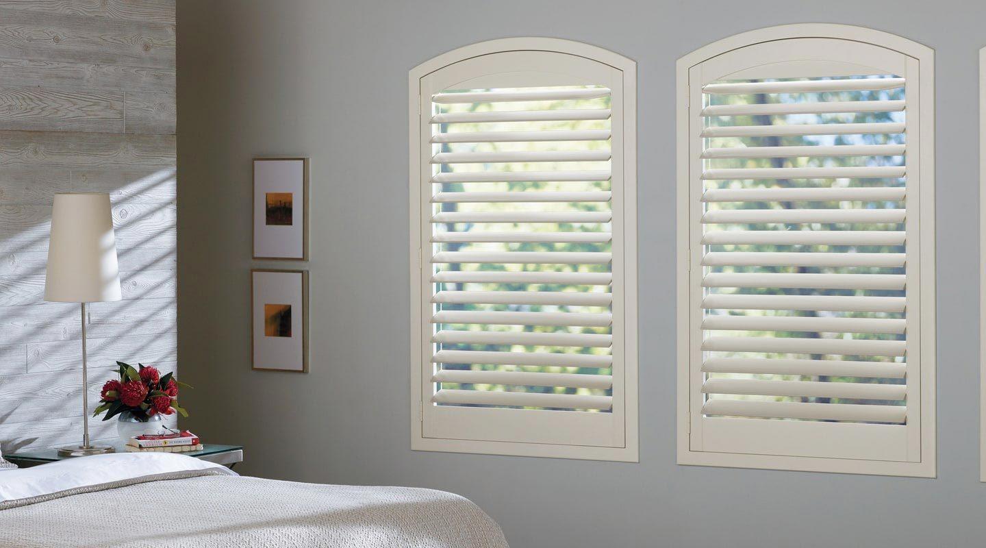 a bedroom featuring Hunter Douglas new style shutters