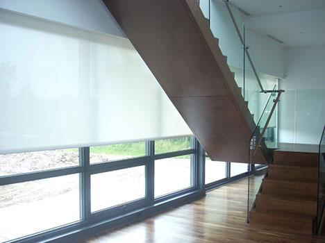 Hunter Douglas blinds next to an open staircase in a house