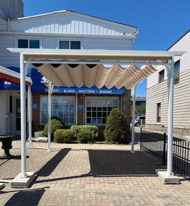 a patio cover outside of the Sunshade Blinds and Drapery storefront in Ajax