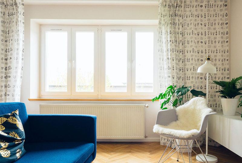 four windows in a living room with floor length drapery