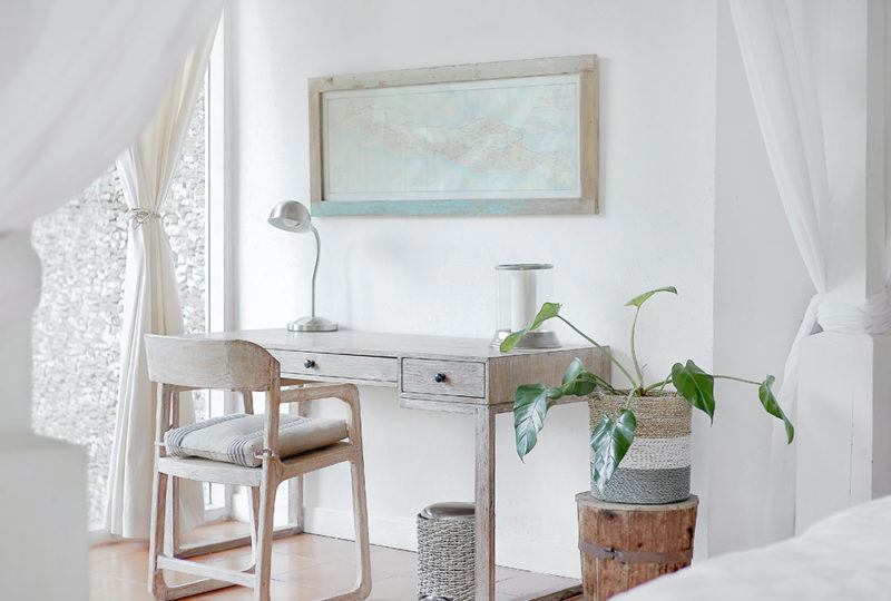 a white desk with white floor length drapes pulled back around it