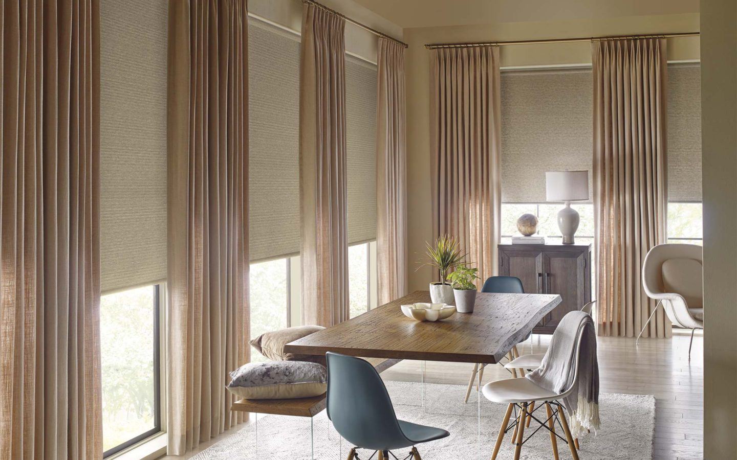 a dining room with floor to ceiling Hunter Douglas Drapery