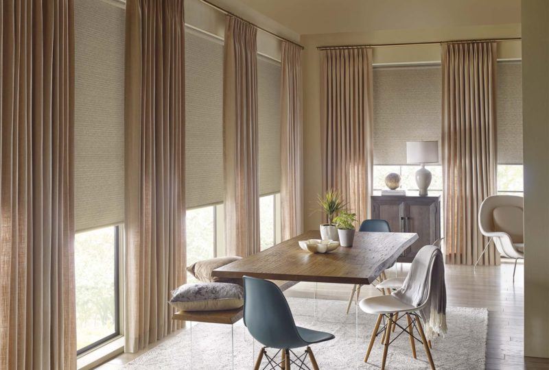 a dining room with floor to ceiling Hunter Douglas Drapery