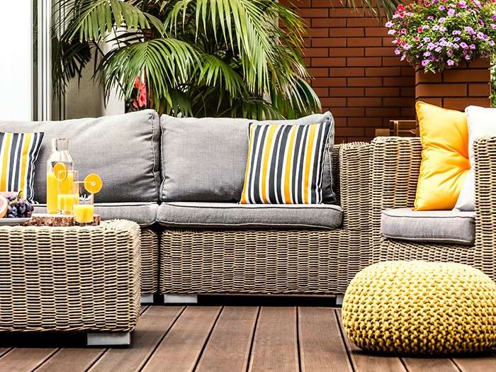 a patio with wicker furniture and potted plants