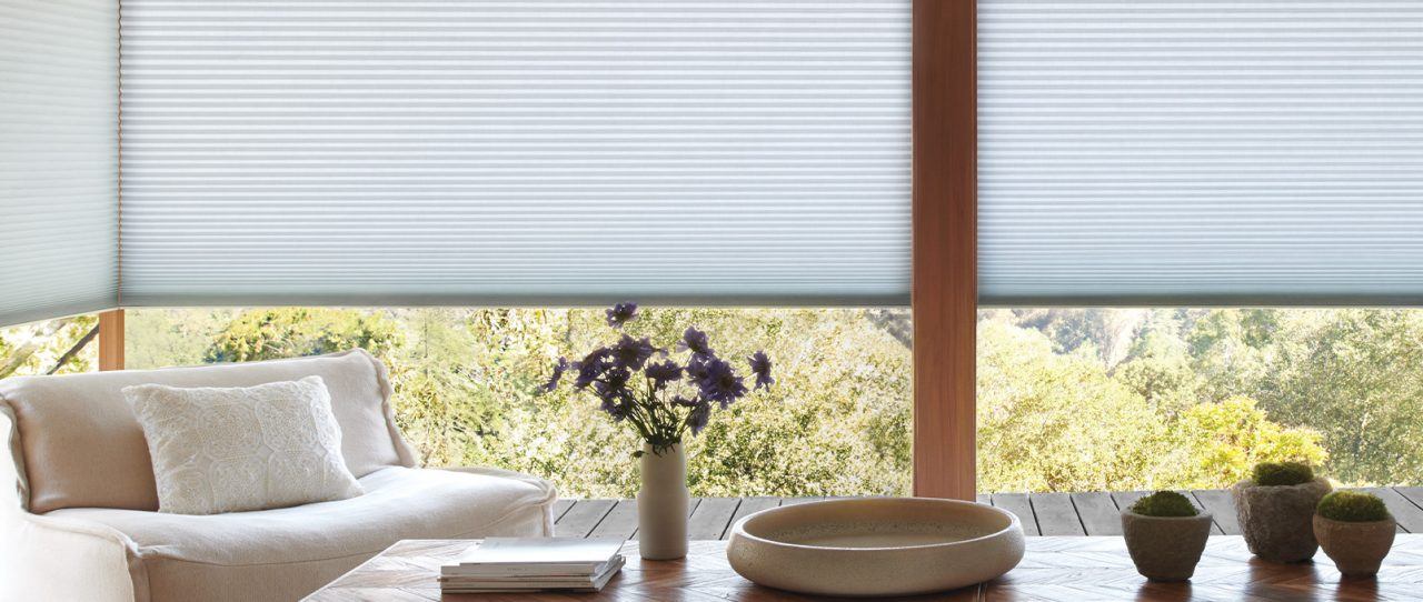 a living room filled with furniture and a window covered in blinds