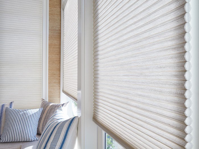 a living room with a couch and a window covered in shades and blinds